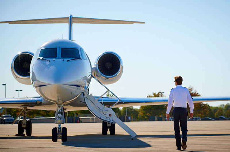 pilot walking on tarmac towards private aircraft