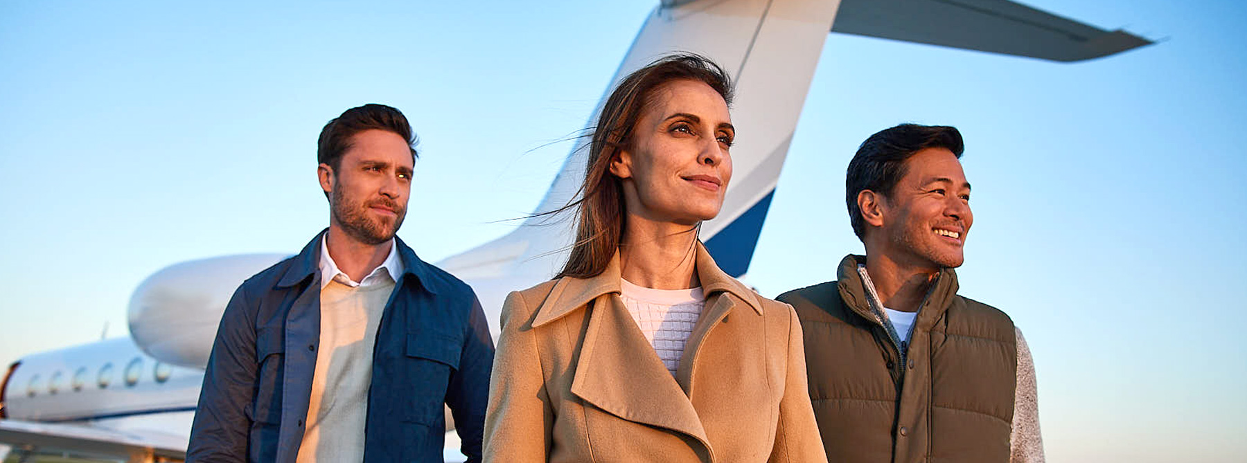 three people standing in front of private aircraft