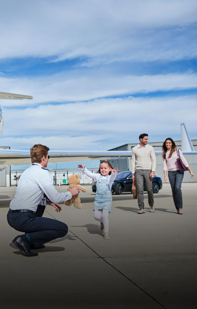 pilot greeting family at a private jet