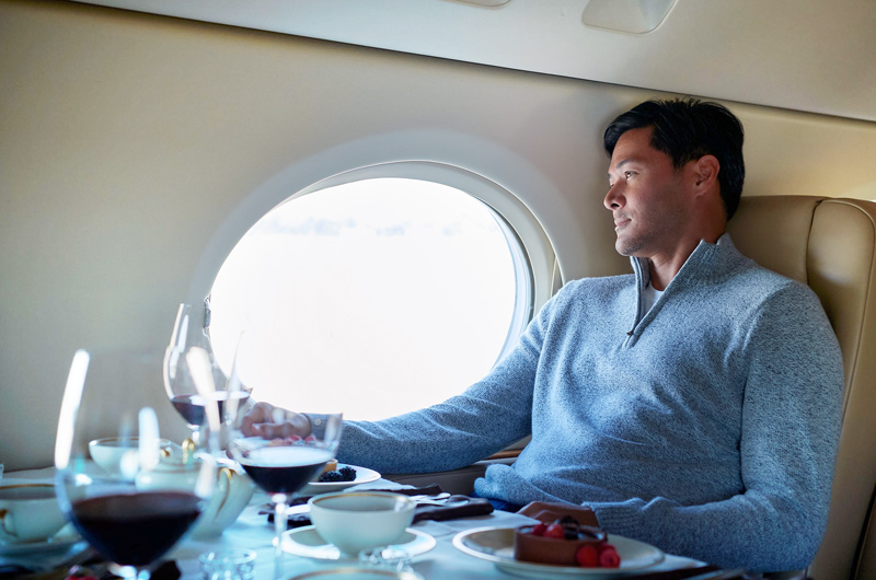 man staring out window on private jet